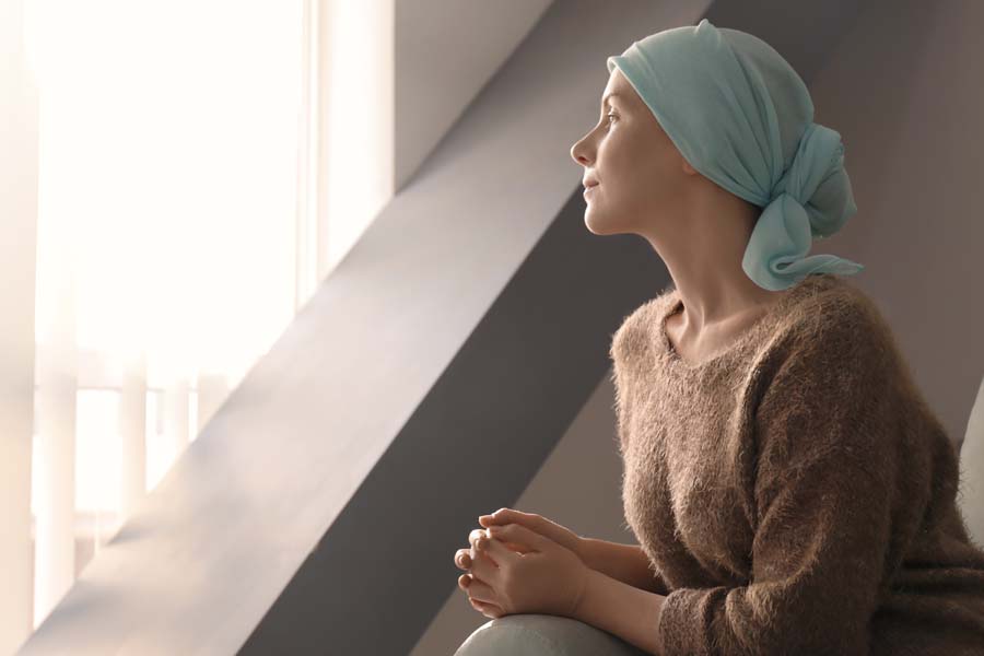 Accident and Critical Illness Insurance - A Woman with Cancer Sitting and Looking Out a Hospital Window